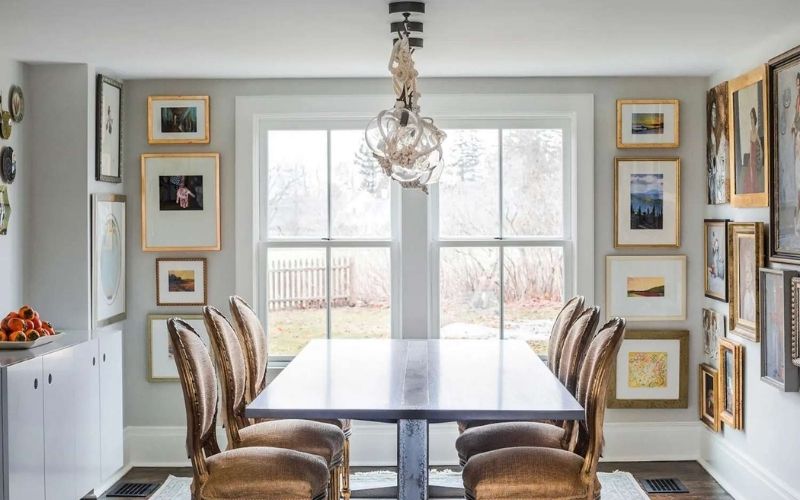 Phòng ăn nhỏ màu xám nhạt, bàn ghế ăn bằng gỗ, trang trí tranh treo tường 