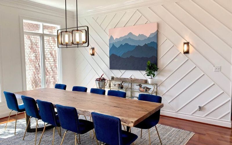 Phòng ăn đẹp với bàn ghế ăn gỗ, bọc đệm xanh, nhấn điểm tranh treo tường