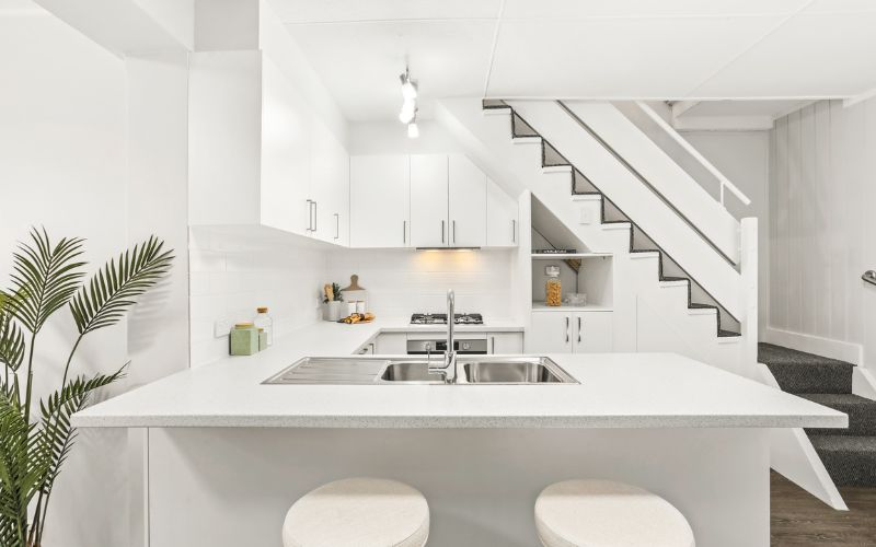 Mẫu bếp dưới cầu thang tone màu trắng hiện đại, bố trí cây xanh tươi mát Tone màu trắng hiện đại, bố trí cây xanh tươi mát