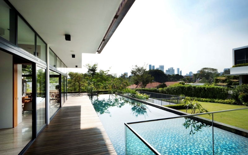 Hồ bơi ngoài trời với làn nước xanh mát xung quanh được bao phủ bởi cây xanh